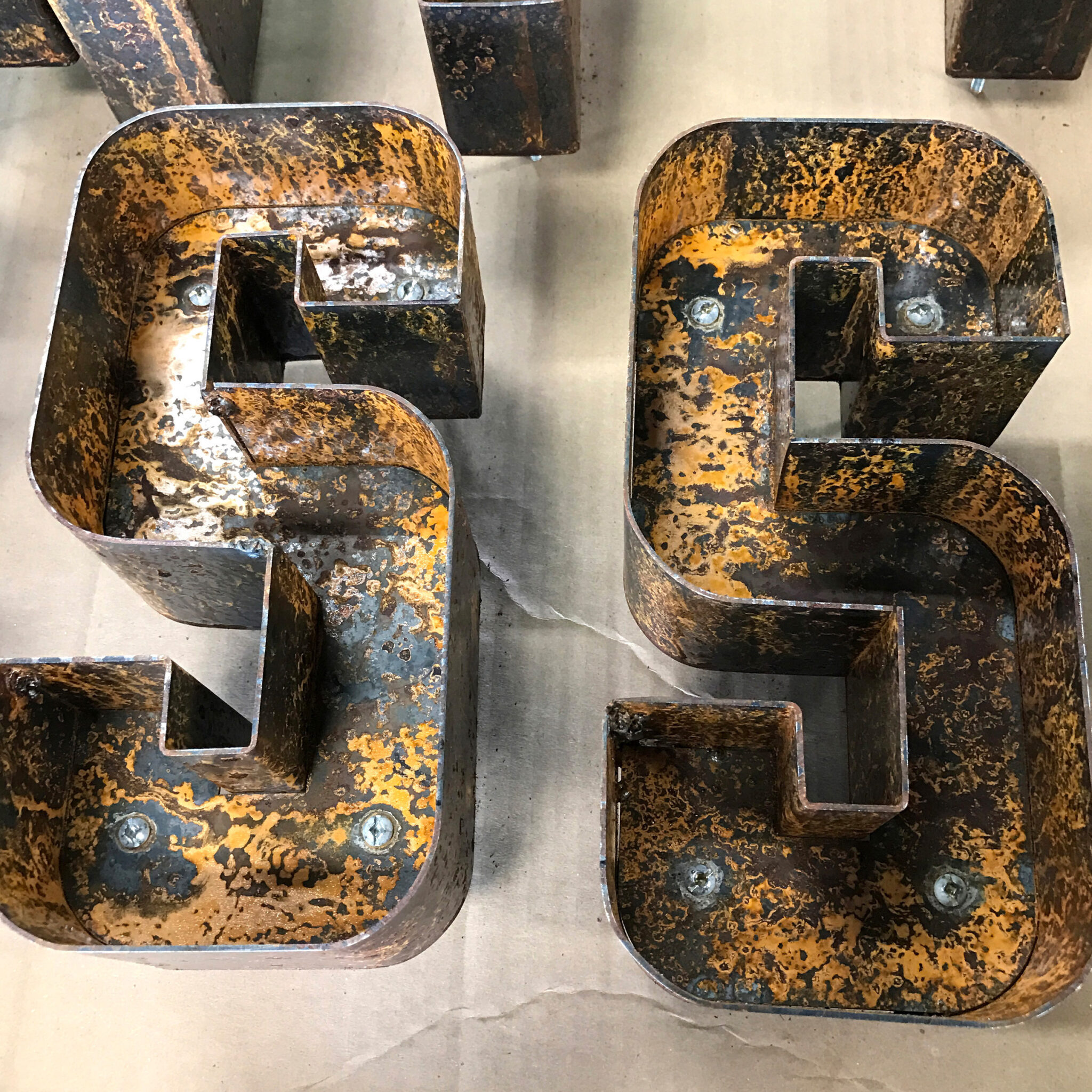 2 Rusted metal letters that say "SS".
